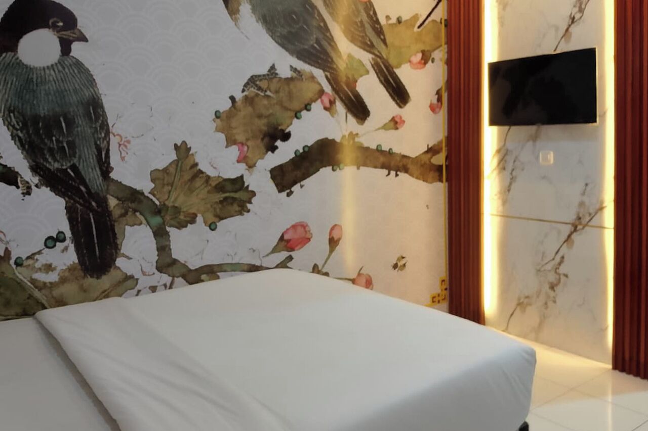 Ein Zimmer mit Bett, einer Wand mit Vogelgemälde, einem Flachbildfernseher und einer Marmorwand.