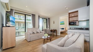 Ein modernes Wohnzimmer mit einer Couch, einem Essbereich und einer Küche.