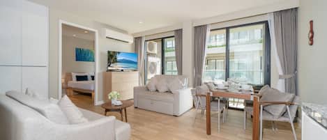 Departamento Deluxe, 2 habitaciones, balcón | Sala de estar | Smart TV de 55 pulgadas con canales por cable