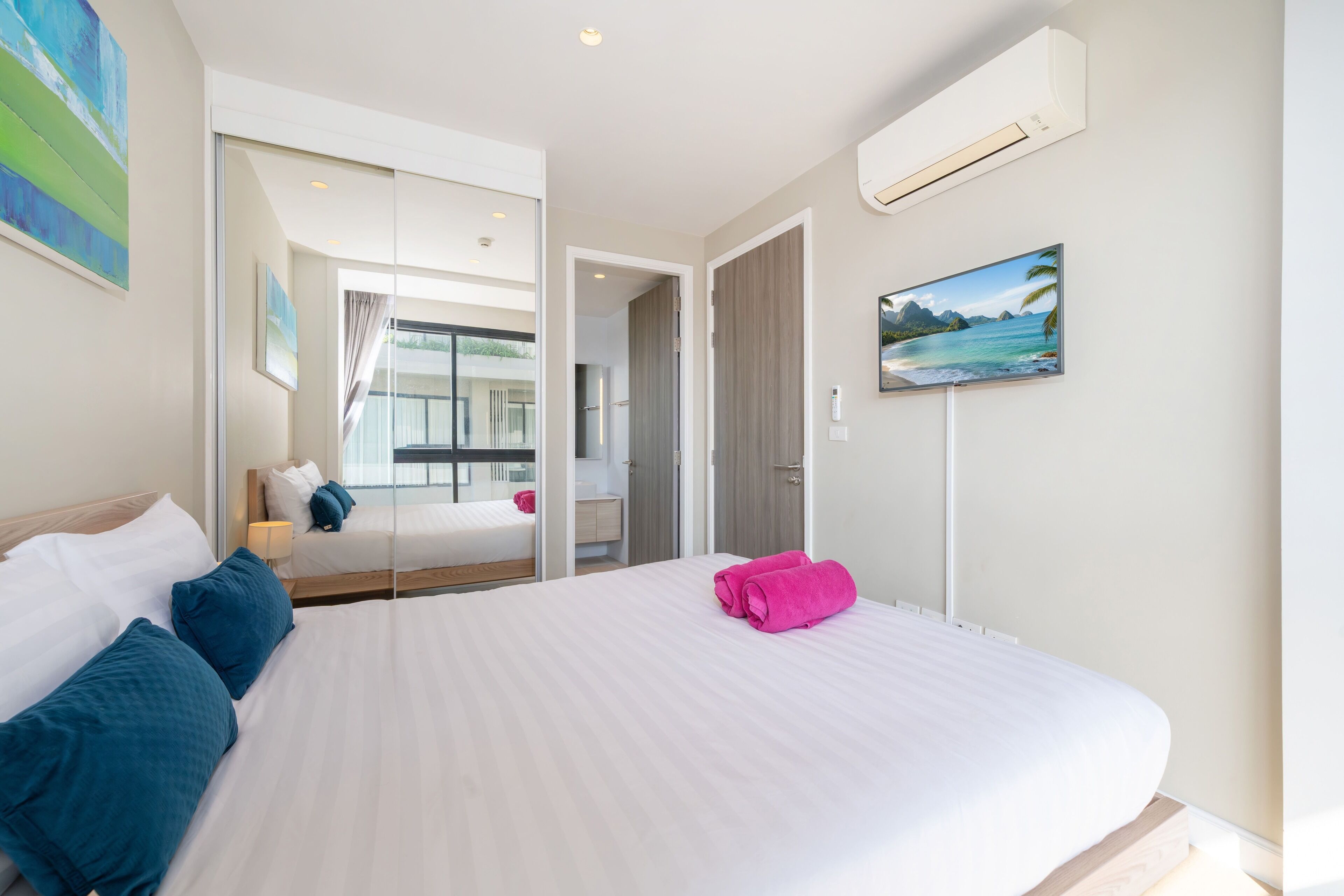 Una habitación de hotel con una cama grande, un baño y vistas al mar.