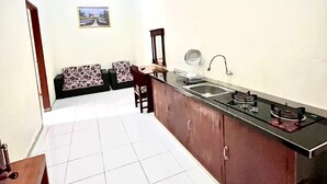 Una cocina con una isla central, una zona de comedor con un sofá y sillas, y una mesa pequeña.