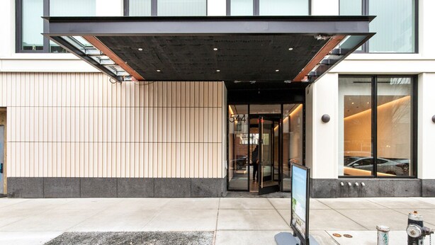 A modern building entrance with a covered walkway, a visible door number '544', and a fire hydrant on the sidewalk. - Blueground | Gowanus, view, nr Prospect Park (New York)