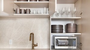 A modern kitchen with a stainless steel sink, a gold faucet, and a built-in microwave. - Blueground | Gowanus, view, nr Prospect Park (New York)
