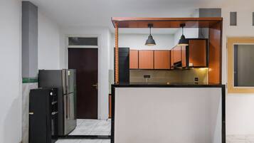 A compact kitchen with a central island, a refrigerator, and a microwave.
