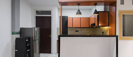 A compact kitchen with a central island, a refrigerator, and a microwave.
