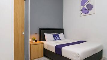 A bedroom with a bed, bedside table, lamp, and a wall art piece.