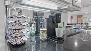 Ett modernt kök med en kaffemaskin, en mjölkskummaskin och en kaffedispenser.