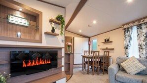 Uma sala de estar moderna com lareira, móveis de madeira e plantas decorativas.