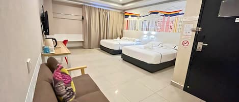 A modern hotel room with a sofa, two beds, a desk with a coffee maker, and a wall with a cityscape mural.