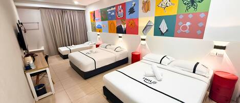 A hotel room with two beds, a desk, a TV, and a colorful wall mural.