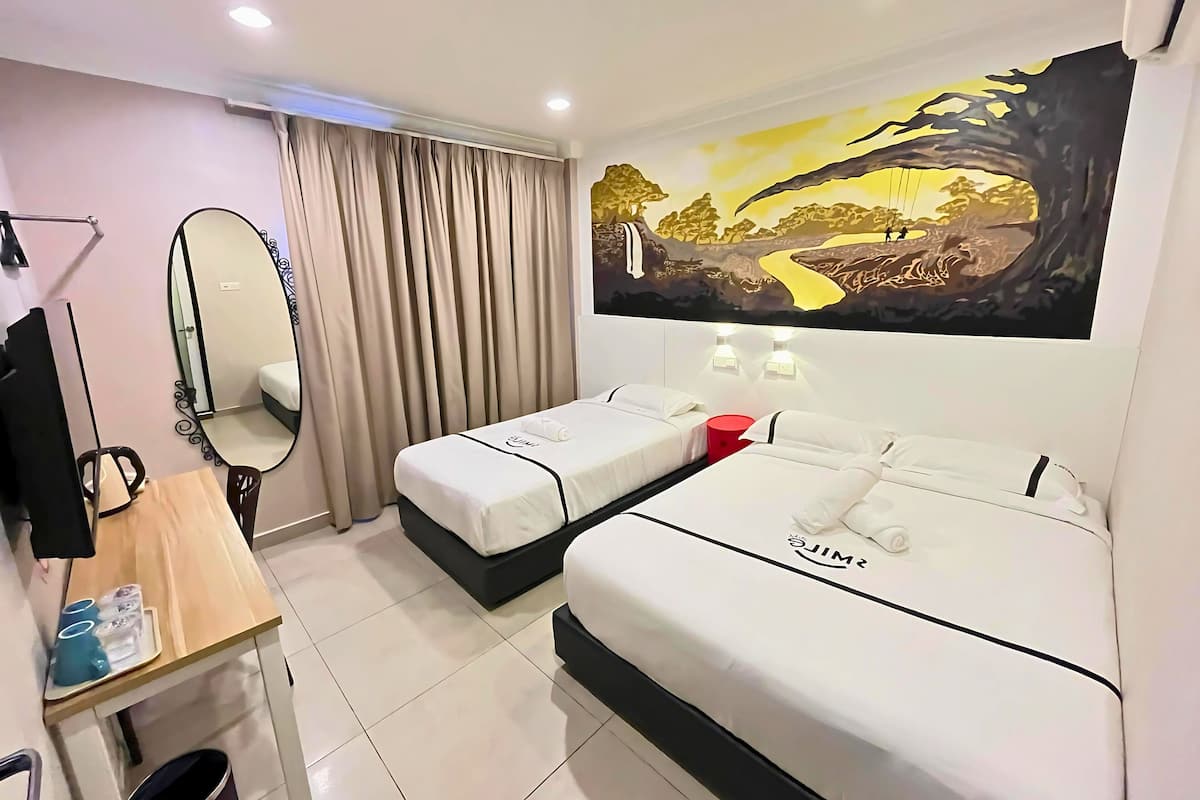 A hotel room with two beds, a desk with a chair, a mirror, and a painting on the wall.