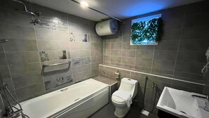 A modern bathroom with a bathtub, toilet, and sink. - Smile Hotel Shah Alam I-City (Shah Alam)