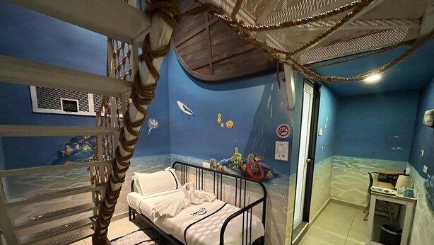 A child's bedroom with a bunk bed, a small desk, and a wall mural of an underwater scene. - Smile Hotel Shah Alam I-City (Shah Alam)