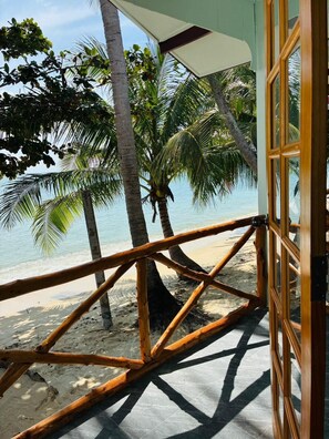 A wooden deck with a view of the beach and palm trees. - Lamai Beachnest Bunaglows (Koh Samui)