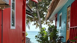 A narrow pathway leading to a beach with a red and blue building. - Lamai Beachnest Bunaglows (Koh Samui)