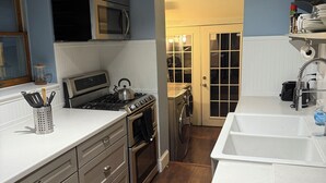 Eine moderne Küche mit Edelstahlgeräten, Holzboden und einer weißen Arbeitsplatte.
