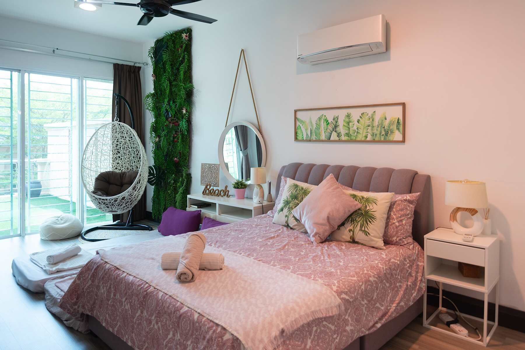 Een slaapkamer met een bed, een hangstoel, een wandairconditioner en een raam met gordijnen.