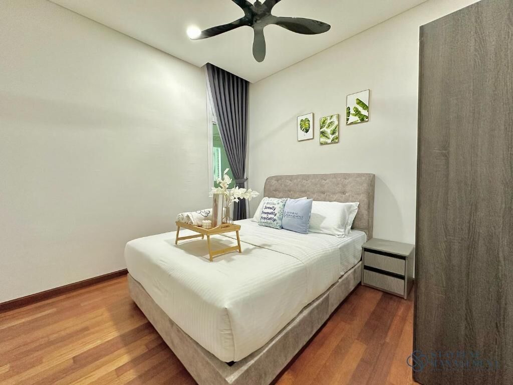A bedroom with a bed, bedside tables, a ceiling fan, and framed pictures on the wall.