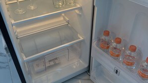 Un réfrigérateur ouvert, avec des étagères et un compartiment congélateur.