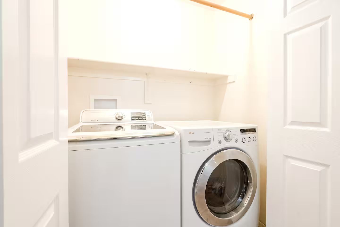 A compact laundry room with a front-loading washing machine and a dryer.