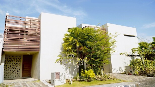 A modern building with a flat roof, a wooden slatted section on the left, and a white facade. - Residence on Opus Bay - Cluny Resorts Villas (Batam)