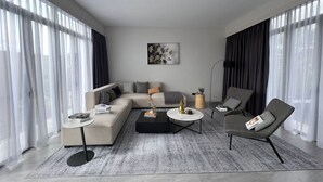 Egy modern nappali, amelyben egy moduláris kanapé, egy dohányasztal és egy kisebb, mellékes asztal található.
