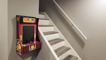 A staircase with a Pac-Man arcade machine mounted on the wall.