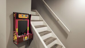 Una escalera con una máquina arcade de Pac-Man fijada a la pared.