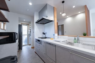 Una cocina moderna con electrodomésticos de acero inoxidable, horno empotrado y un amplio ventanal.