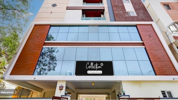 A modern building with a large glass facade, a sign reading "Collection", and a visible entrance.
