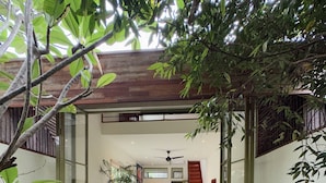 Una casa moderna con puerta de cristal de entrada, una escalera, zona de comedor y cocina.