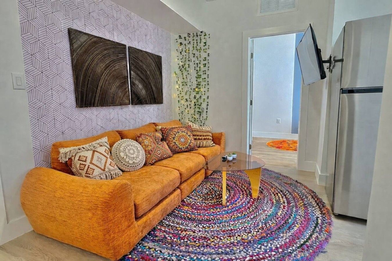 A modern living room with a sofa, a coffee table, and a colorful rug.