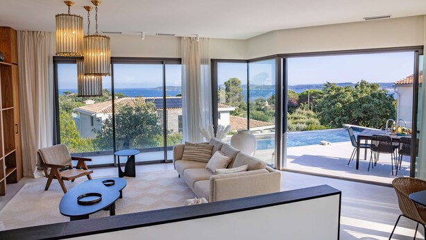 A modern living room with a sofa, chairs, and a dining table, overlooking a pool and scenic views. - Contemporary villa with heated pool, close to the town centre (STE MAXIME)