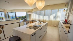A modern kitchen with a central island, large windows, and a view of the sea. - Contemporary villa with heated pool, close to the town centre (STE MAXIME)