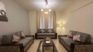 A living room with two sofas, a coffee table, and a chandelier. - "Samaraham Residency" 3-bedroom fully furnished apartments in Taqah, Salalah! (Taqah)