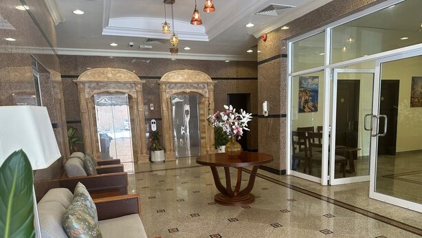 A lobby with a reception desk, seating area, and a glass door entrance. - "Samaraham Residency" 3-bedroom fully furnished apartments in Taqah, Salalah! (Taqah)
