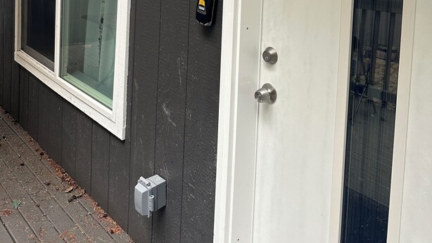 Ein Haus mit weißer Tür, einer Garagentür und einem Fenster.