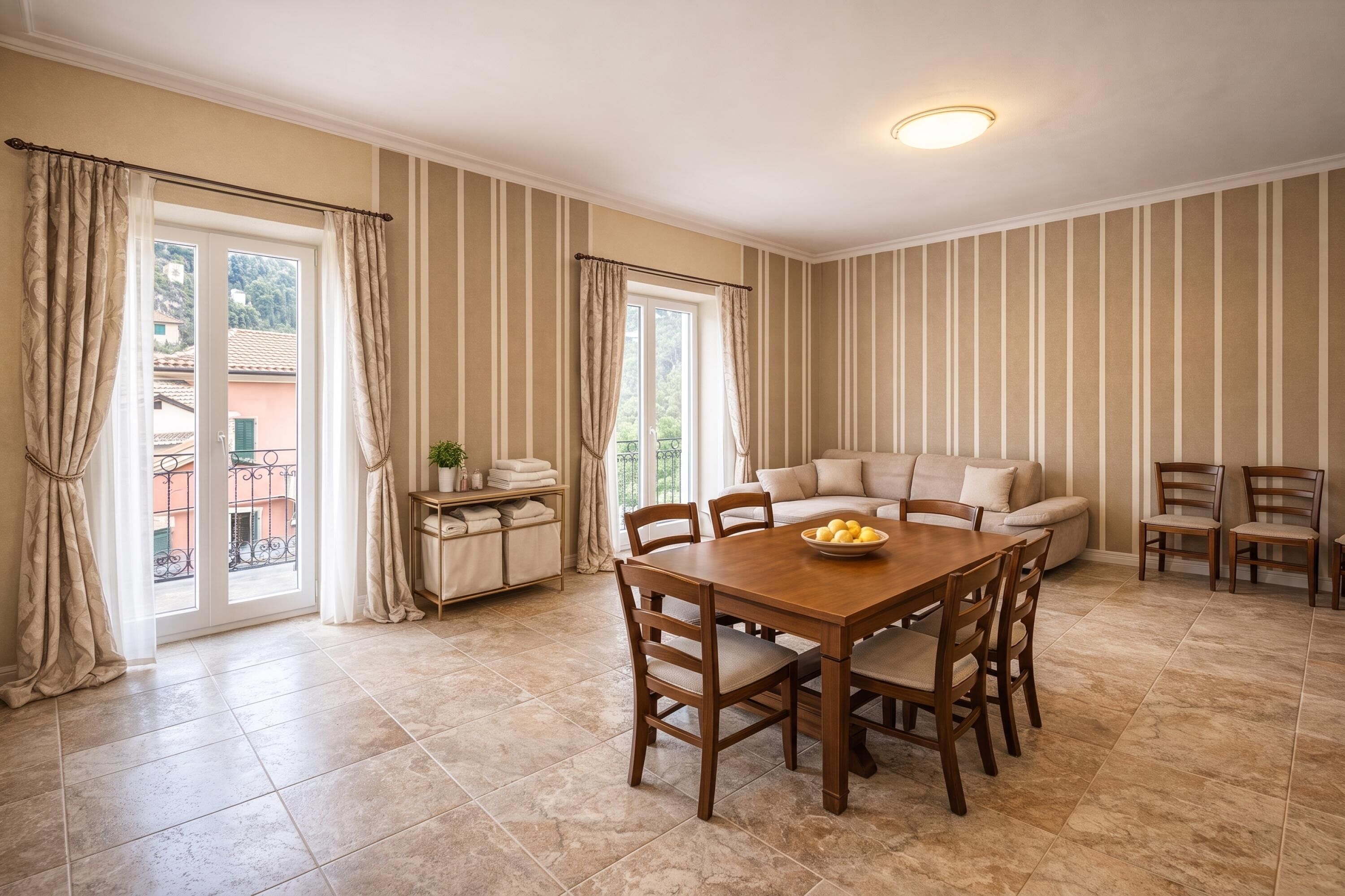 A dining area with a wooden table and chairs, a sofa, and striped walls.