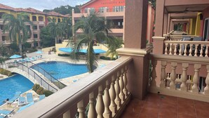 Un hotel con piscina, puente y una palmera.