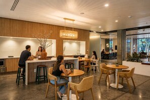 A modern interior with a bar area, seating, and a view through a glass wall. - Chic Downtown Phoenix Gem w/ Scenic Balcony & Park (Phoenix)