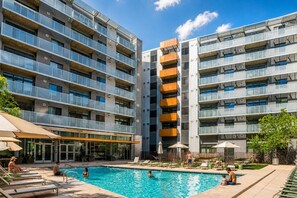 A modern multi-story building with a swimming pool, outdoor seating, and a clear sky. - Chic Downtown Phoenix Gem w/ Scenic Balcony & Park (Phoenix)