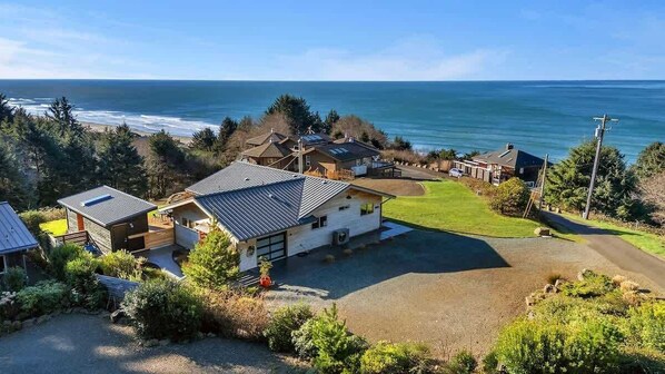 A coastal property with multiple houses, a driveway, and a view of the ocean. - Sea to Sky Retreat by Manzanita Beach Getaway: Ocean Views, 3BR Hilltop Home (Nehalem)