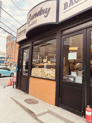 A coffee shop named 'Sunday' with a display of baked goods in the window.