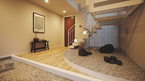A modern interior with a wooden floor, a staircase, a small table with a vase, and a framed picture on the wall. - 2025/12 New Open! villa(232 m2) 4min Shinjuku, 10min Shibuya, 3 Free parking (渋谷区初台1丁目)