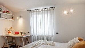 Une chambre à coucher avec un lit, un bureau et une chaise.