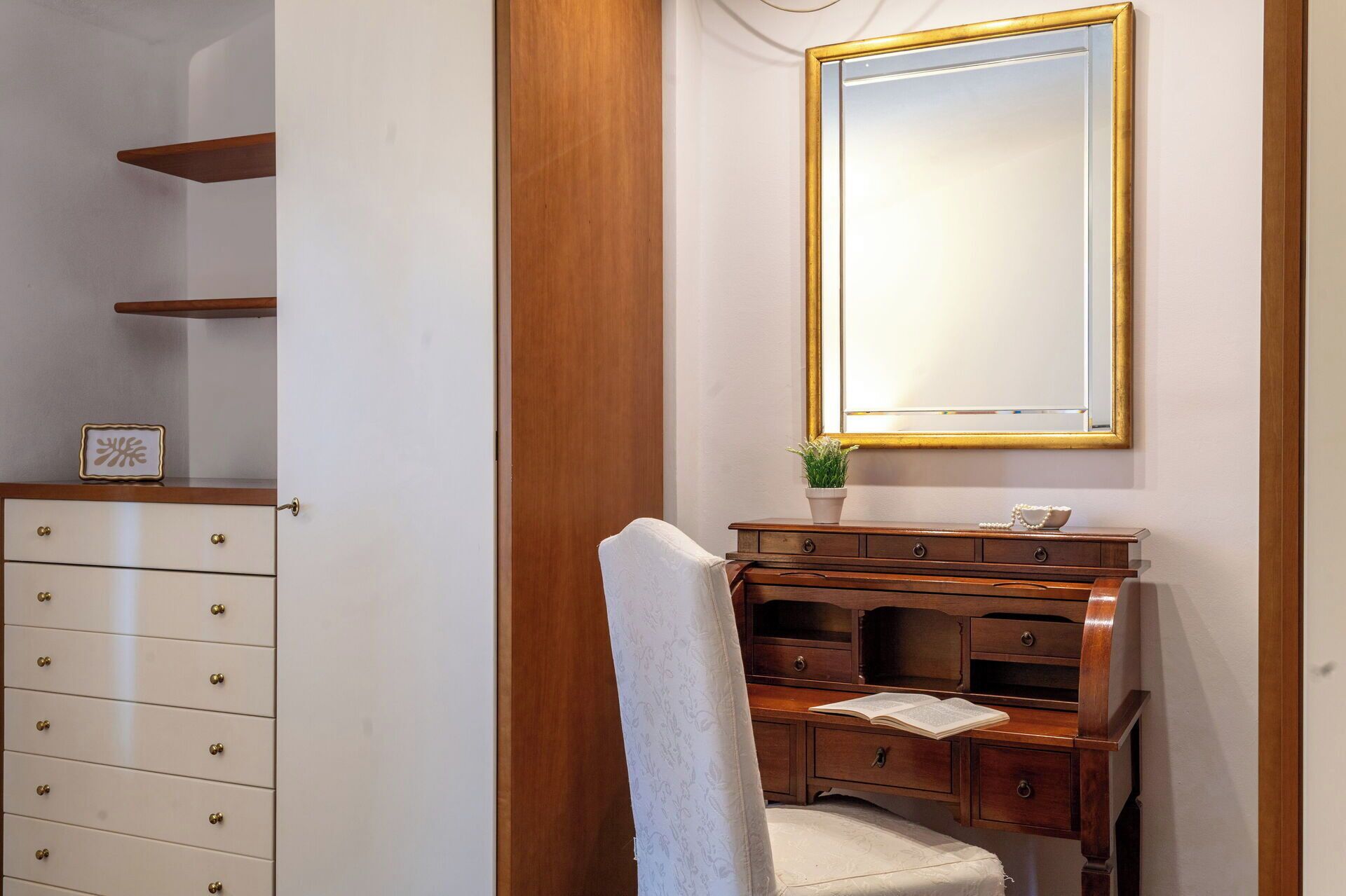 Une salle de bain avec un meuble-lavabo en bois, un miroir et une serviette accrochée au mur.