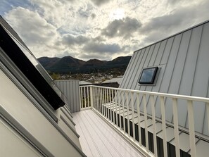 Ein Balkon mit Blick auf Berge und eine Stadt.