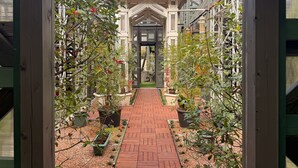 A brick pathway leading to a building entrance with a covered porch and potted plants. - Yufuin Onsen 8A1 Yaeichi (Yufu)