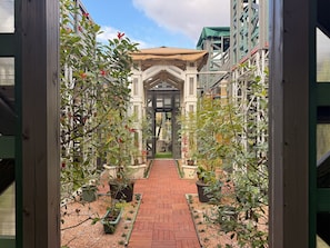 A brick pathway leading to a building entrance with a covered porch and potted plants. - Yufuin Onsen 8A1 Yaeichi (Yufu)