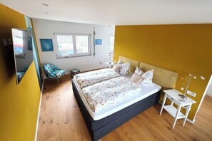 A bedroom with a bed, bedside table, and a chair. - Modern, well-maintained, and cozy vacation apartment in Donaustauf near Regensburg, 3.5 bedrooms (Donaustauf)